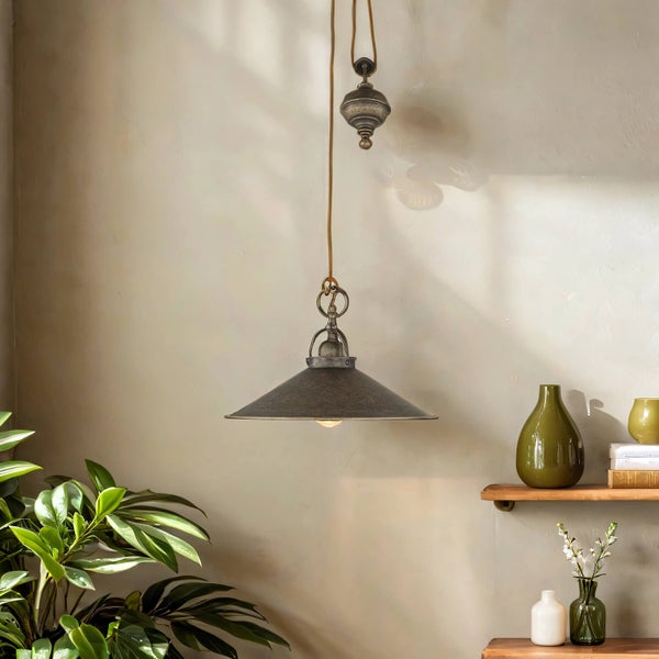 Innenaufnahme einer höhenverstellbaren Hängelampe aus Metall über einer Pflanze und Regalen mit Vasen