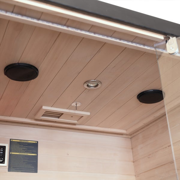 Innenansicht einer Sauna mit Holzpaneelen an Decke und Wand, inklusive integrierten Lautsprechern, Beleuchtung und Lüftungsschlitz.