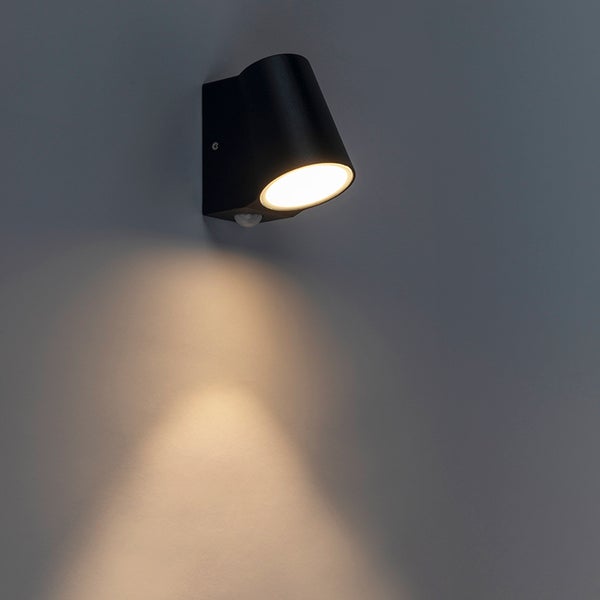 Moderne schwarze LED-Außenwandleuchte in Zylinderform mit Bewegungsmelder, Lichtkegel nach unten gerichtet.