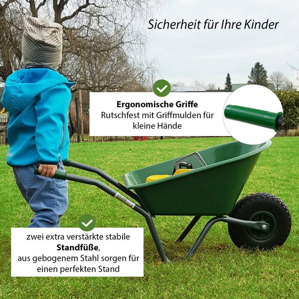 Kind schiebt grüne Schubkarre im Garten