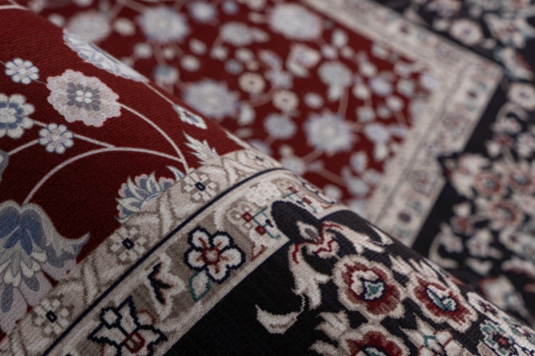 Teppich mit klassischem Blumenmuster und detaillierter Bordüre in Nahaufnahme.