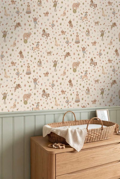 Kindertapete mit Zirkusmotiven wie Elefanten und Tieren in einem Babyzimmer mit Wickelkommode und geflochtenem Korb