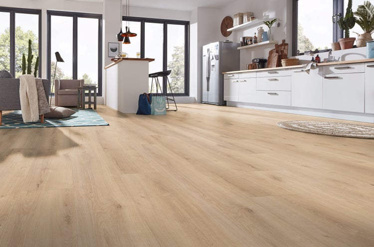 Heller Laminatboden in Holzoptik in einem offenen, lichtdurchfluteten Wohnbereich mit moderner Küche und integriertem Wohnzimmer.