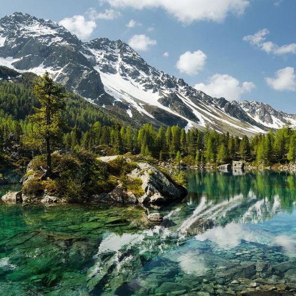 Landschaft mit Bergsee, Felseninsel und schneebedeckten Bergen