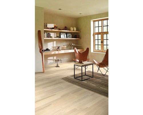 Heller Raum mit Holzboden, Regalen, Dekoration und zwei Sesseln