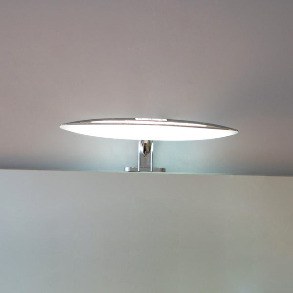 LED-Spiegelleuchte in flacher, ovaler Form aus verchromtem Metall, auf einem Spiegel montiert und eingeschaltet.