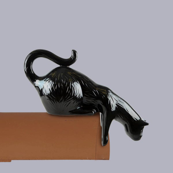 Firstschmuck Katze aus schwarzer, glasierter Keramik auf einem Firstziegel.