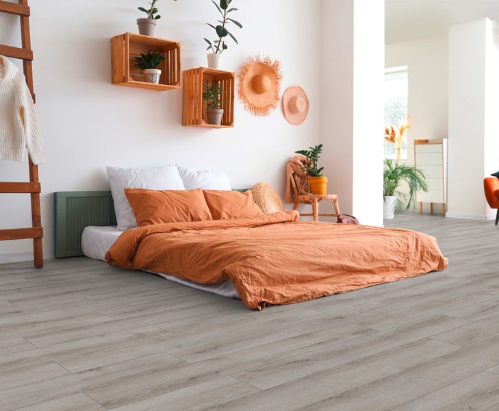 Helles Laminat in Holzoptik in einem modern eingerichteten Schlafzimmer mit einem niedrigen Bett und rustikalen Wandregalen aus Holzkisten.