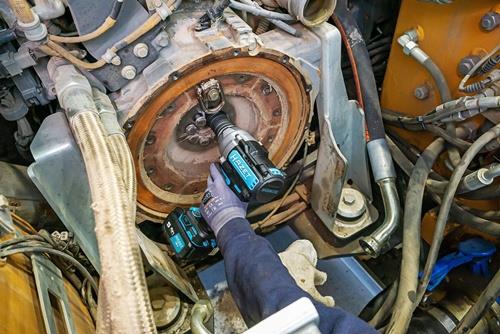 Eine Person verwendet einen Akku-Schlagschrauber der Marke Hazet zur Reparatur einer Maschine.