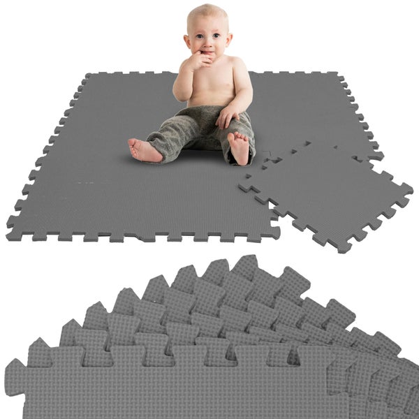 Graue Puzzlematten aus weichem Schaumstoff als Schutzmatte oder Spielmatte, Set mit ineinandergreifenden Einzelteilen und einem sitzenden Baby.