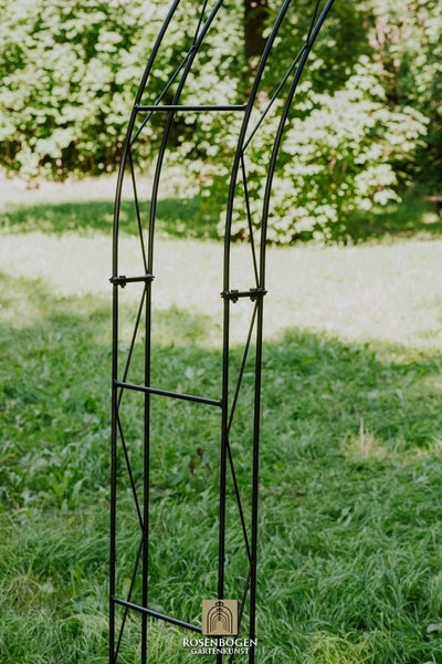 Detailansicht eines Rosenbogens aus Metall im Garten