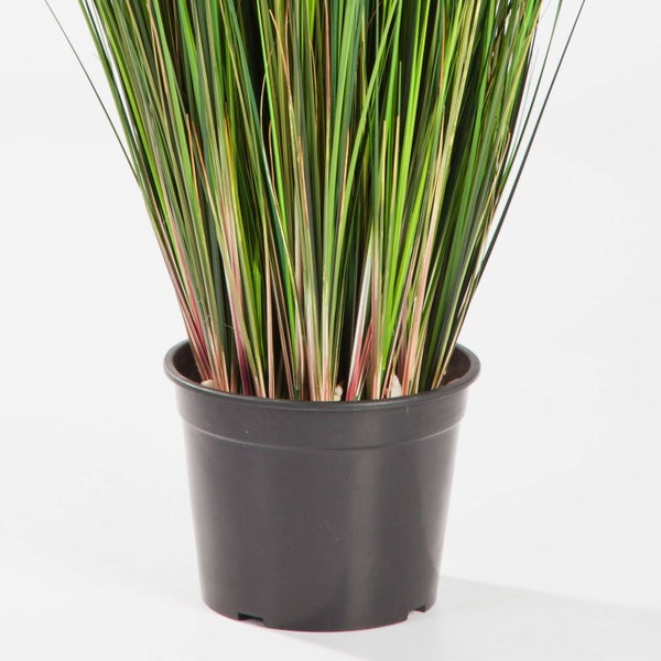 Künstliches Gras in einem schwarzen Kunststofftopf mit bunten Halmen.