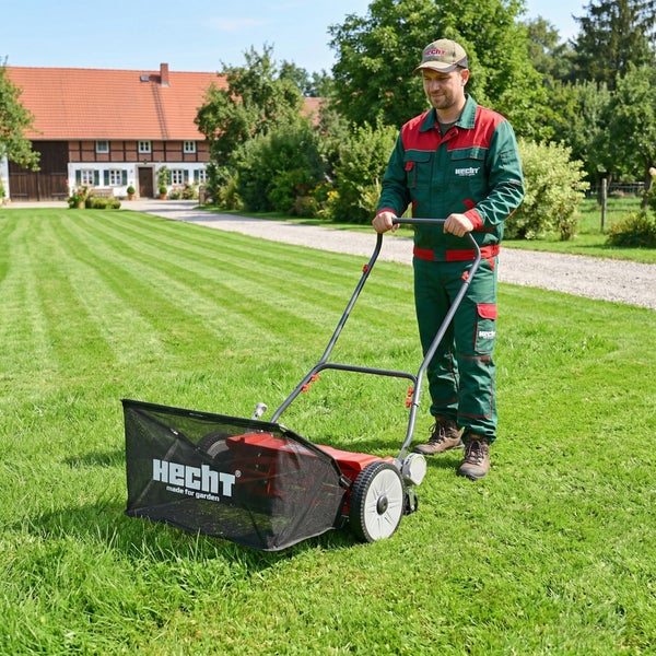 Ein Mann benutzt einen Rasenlüfter im Garten, um den Rasen zu pflegen.