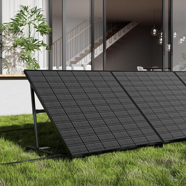 Tragbares Solarmodul im Garten vor einem Haus