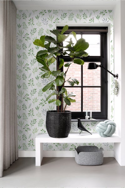 Innenraumszene mit Zimmerpflanze, dekorativen Objekten und Blumentapete