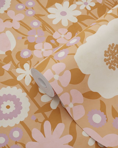 Vliestapete mit großem Retro-Blumenmuster in Rosa, Weiß und Ocker.