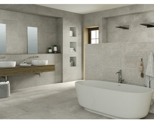 Helles Badezimmer mit Badewanne, Waschtischen und grauen Fliesen