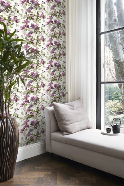 Dekoratives Wohnzimmer mit floraler Tapete, Tagesbett und Zimmerpflanze.