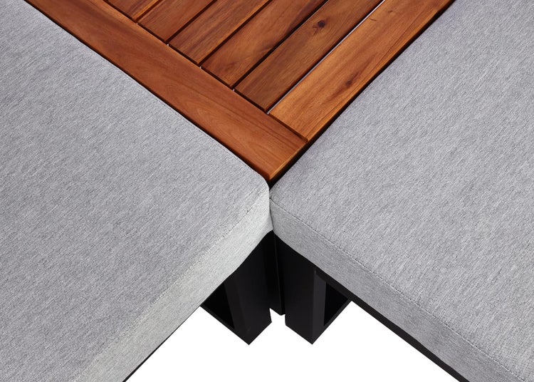 Nahaufnahme einer Gartenlounge-Ecke mit Holzlatten und Polstern aus Stoff.