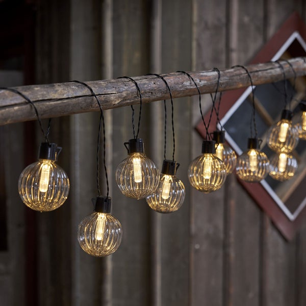 Lichterkette mit runden Lampen an einem Ast aufgehängt