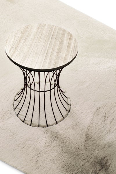 Beistelltisch mit runder Tischplatte in Holzoptik und schwarzem Metallgestell auf hellem Hochflor-Teppich.