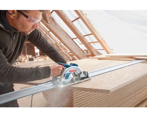 Mann sägt mit Handkreissäge Holzplatte