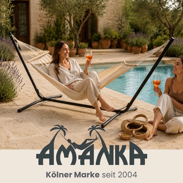 Frau entspannt in einer hellen Baumwollhängematte mit schwarzem Metallgestell am Pool auf einer Steinterrasse. Mediterraner Stil. Amanka Logo.