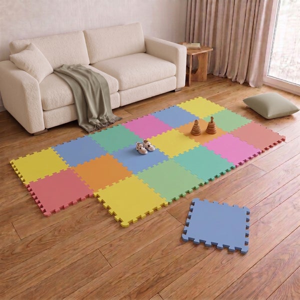 Bunte Schaumstoff Puzzlematte für Kinder auf einem Holzboden in einem Wohnzimmer mit Sofa und Spielzeug.