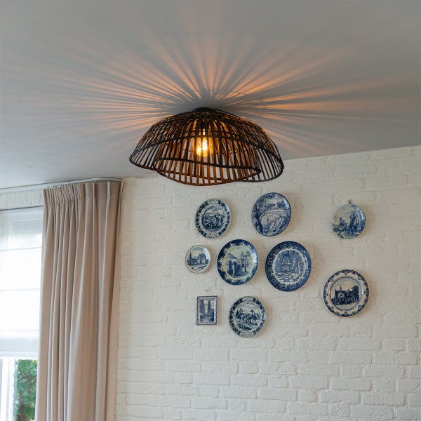 Deckenleuchte aus Rattan im Interieur mit Dekoration an der Wand