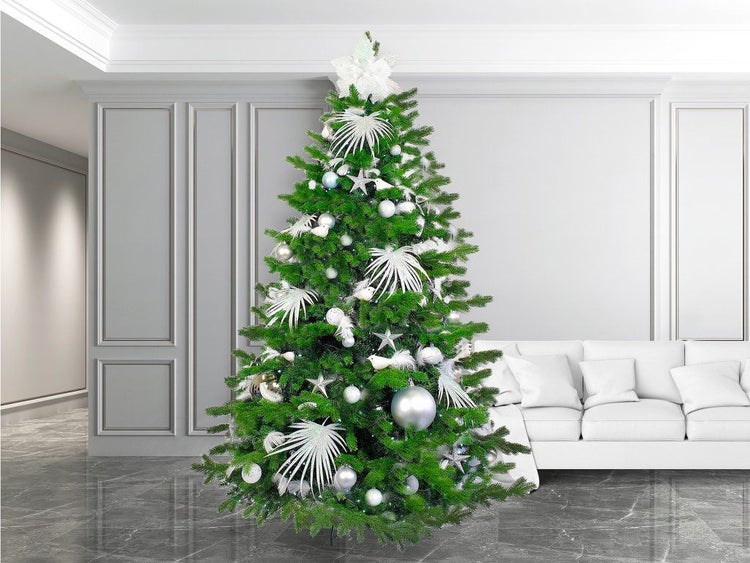 Geschmückter künstlicher Weihnachtsbaum in einem modern eingerichteten Wohnzimmer mit hellem Sofa und klassischer Wandverkleidung.