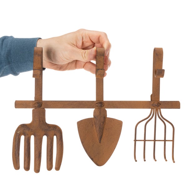 Garderobenleiste mit Haken in Form von Gartenwerkzeugen wie Gabel, Schaufel und Harke in Rost-Optik.