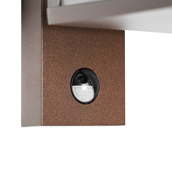 Nahaufnahme eines Bewegungsmelders an einer Außenwandleuchte mit strukturierter Oberfläche.