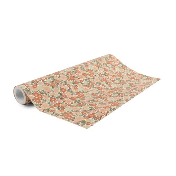 Teilweise ausgerollte Tapetenrolle mit dichtem Blumenmuster im Retro-Stil für die Innenraumgestaltung.