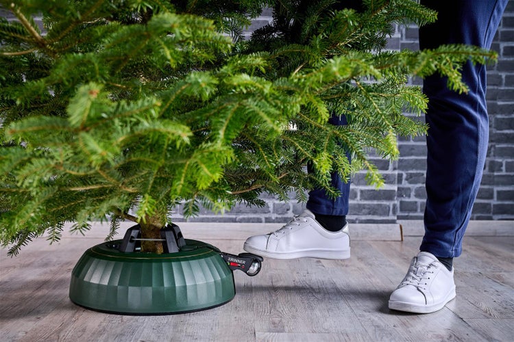 Eingespannter Weihnachtsbaum im Baumständer mit Fußbedienung