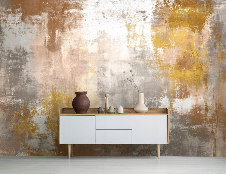 Abstrakte Fototapete mit strukturierter Oberfläche hinter einem weißen Sideboard mit dekorativen Vasen.