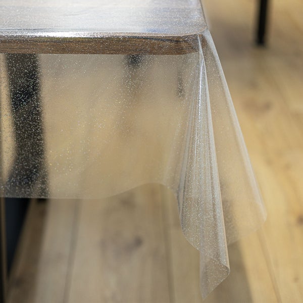 Transparente Tischdecke mit Glitzereffekt auf einem Holztisch.