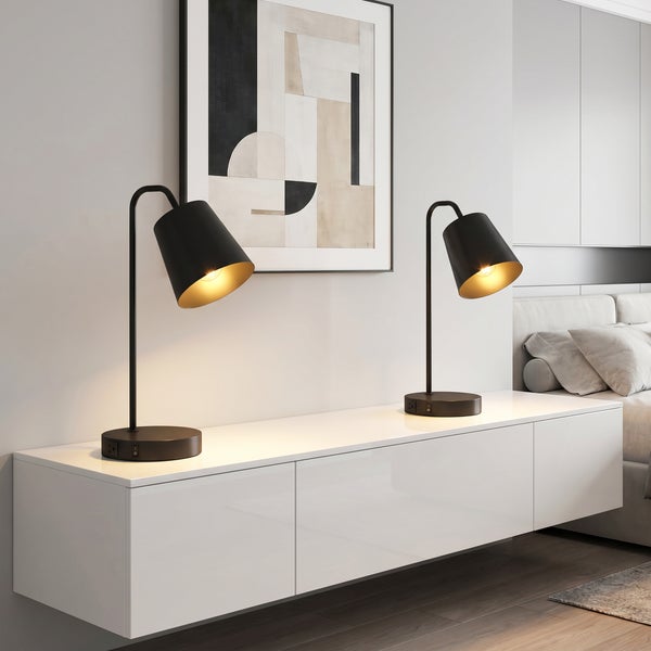 Zwei moderne Tischleuchten mit Schirm auf einem weißen Sideboard in einem Schlafzimmer mit abstrakter Wandkunst.