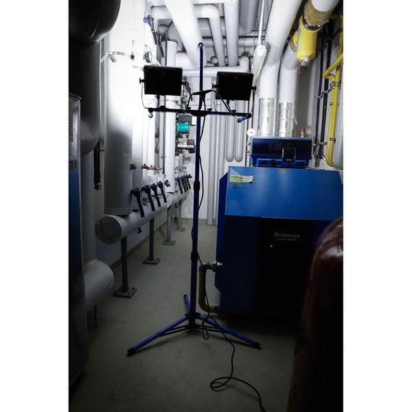 LED-Baustrahler mit zwei Flutern auf einem höhenverstellbaren blauen Stativ.