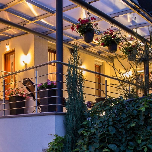 Blick auf einen Balkon mit Überdachung, Geländer und bepflanzten Blumenkästen