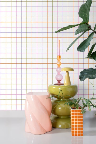 Vliestapete mit handgezeichnetem Karomuster in bunten Farben in einem modern eingerichteten Wohnbereich mit verschiedenen Wohnaccessoires.