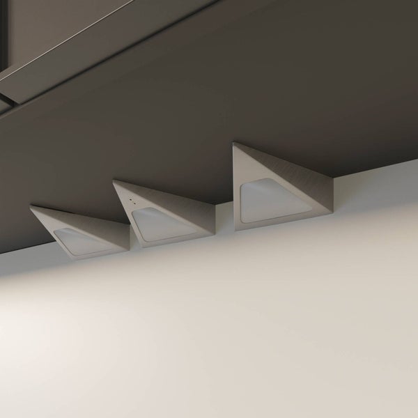 Drei dreieckige LED-Unterbauleuchten in Edelstahloptik gebürstet, unter einem Regal montiert.