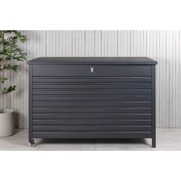 Anthrazitfarbene Gartenbox aus Metall mit gerippter Front, Deckel, Rollen und Verschlussriegel vor einer Holzwand.