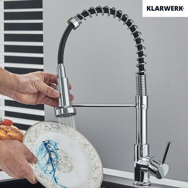 Klarwerk Küchenarmatur mit herausziehbarer Geschirrbrause und Spiralfeder beim Abspülen eines Tellers.