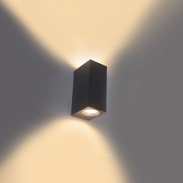 Rechteckige Außenwandleuchte aus dunklem Metall, die warmes Licht nach oben und unten an eine Wand strahlt.