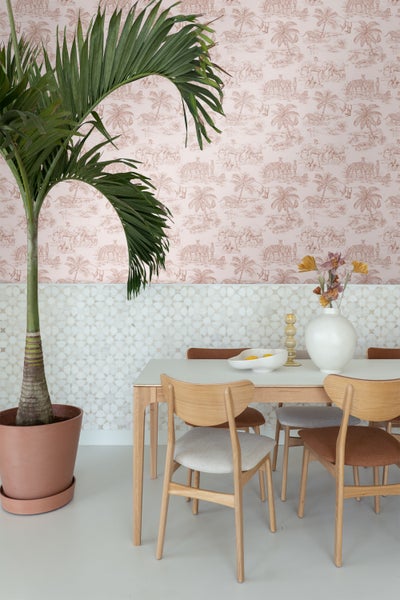 Esszimmer mit Esstisch, Stühlen und Zimmerpflanze in einem Topf