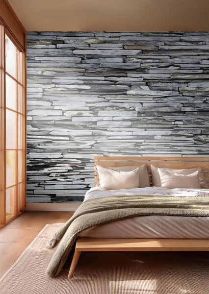 Schlafzimmer mit Steinwand-Tapete und Holzbett