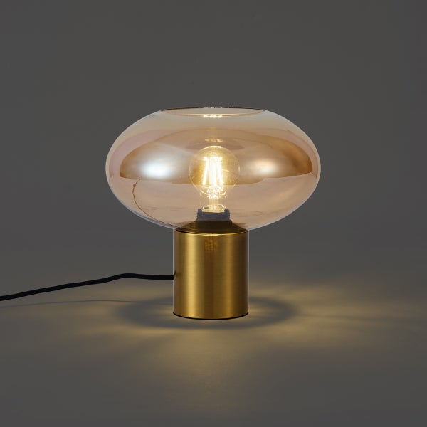 Moderne Tischleuchte mit goldfarbenem Metallfuß und ovalem Glasschirm in Bernsteinoptik.