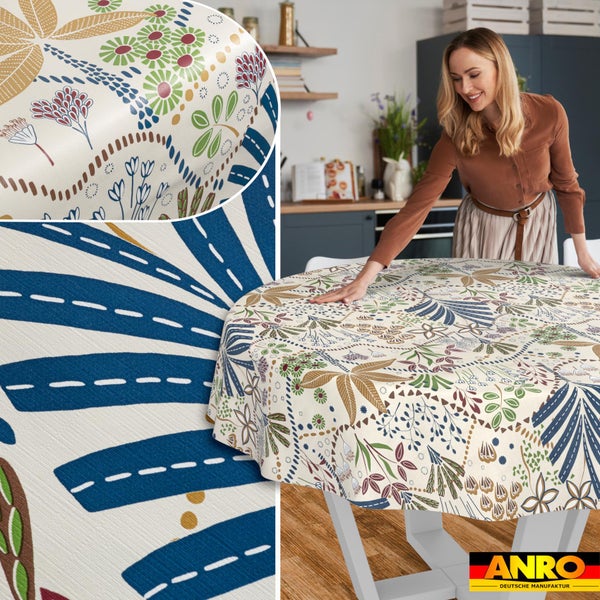 Eine Frau glättet eine runde Tischdecke mit floralem Muster auf einem Tisch in einer hellen Küche. Detail der abwaschbaren Oberfläche und ANRO Logo.