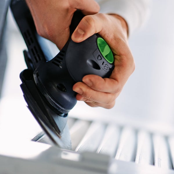 Mann verwendet Farbsprühsystem zum Streichen von Heizkörpern