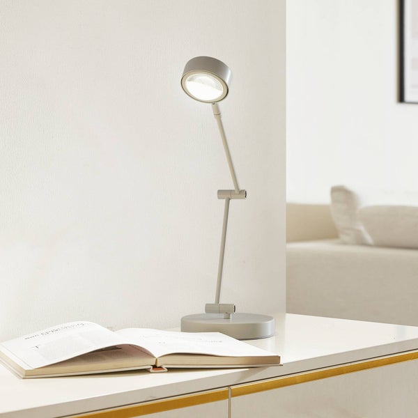 Verstellbare Schreibtischlampe auf einem Schreibtisch mit einem offenen Buch